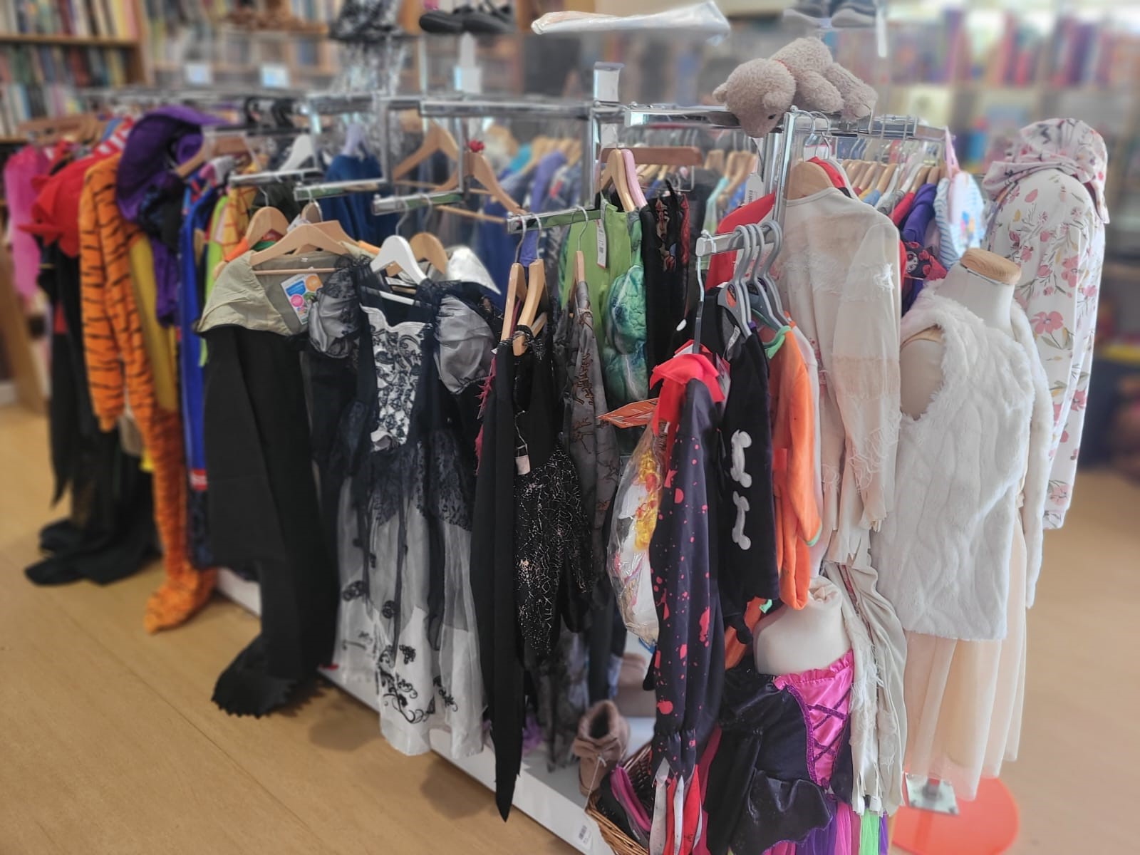 A rail of Halloween costumes at a charity shop