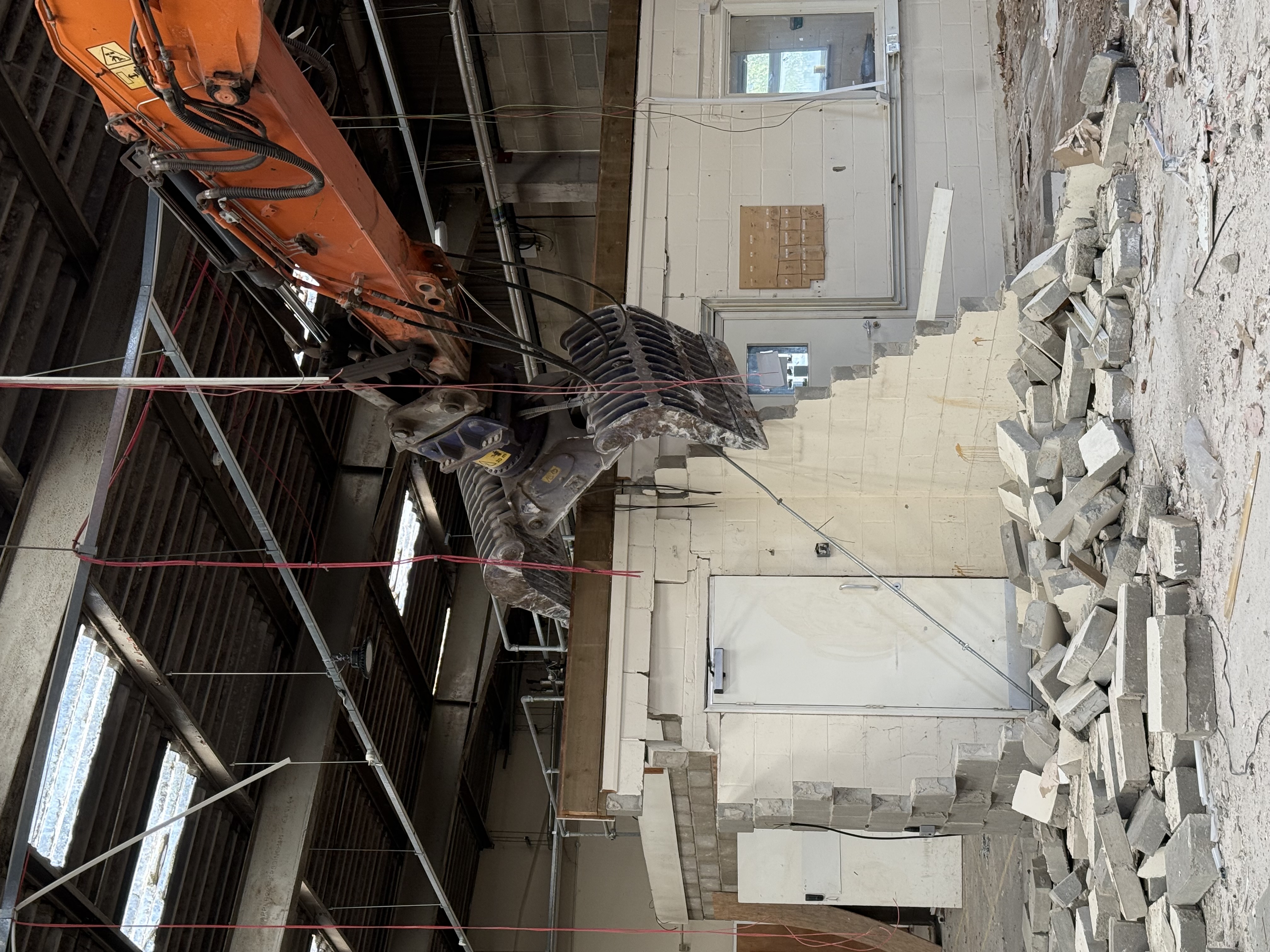 A digger tearing down an old wall inside Gipping House, Ipswich.