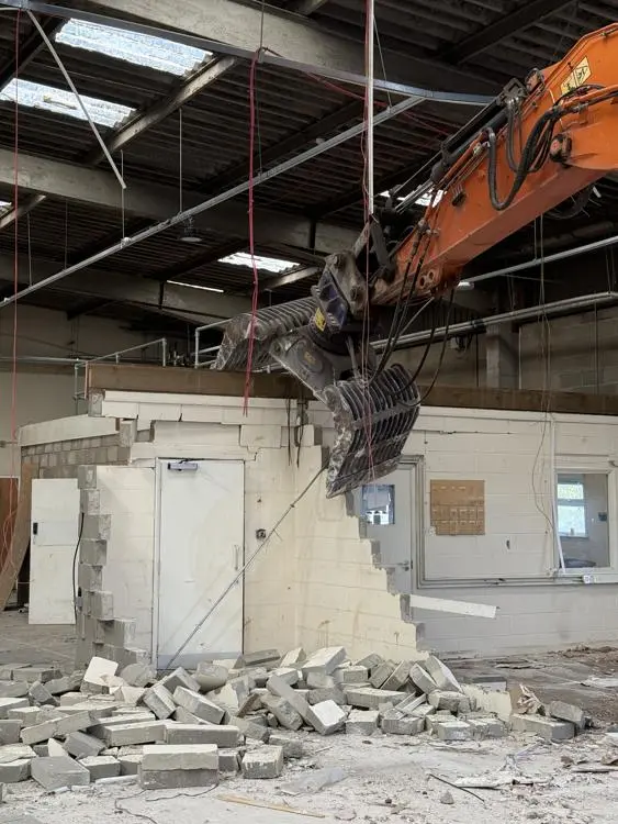 A digger tearing down an old wall inside Gipping House, Ipswich.