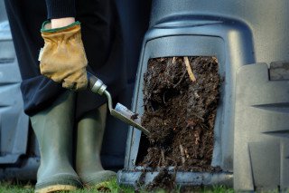 Person taking compost out of a compost bin. 