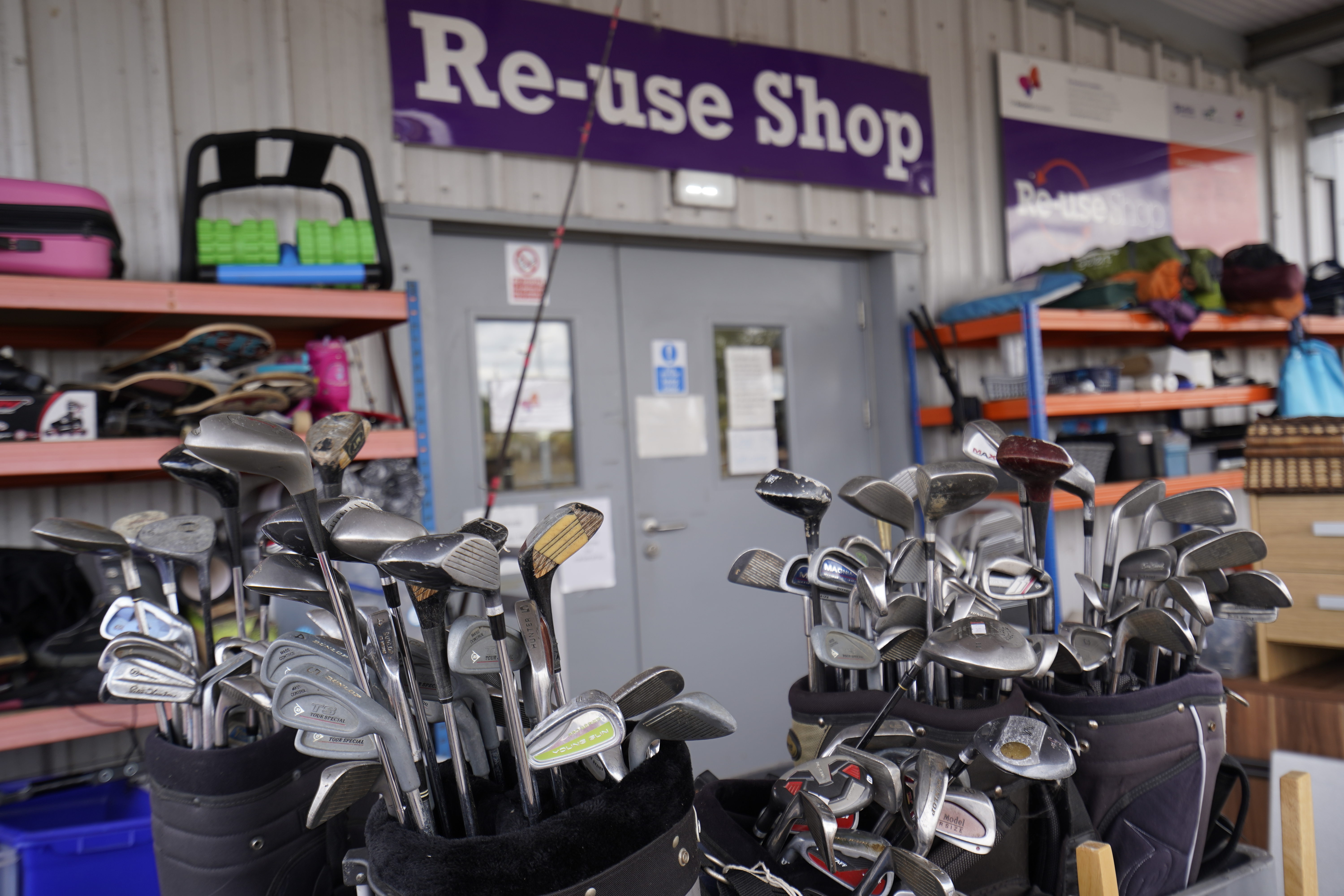 Golf clubs with re-use sign in background.