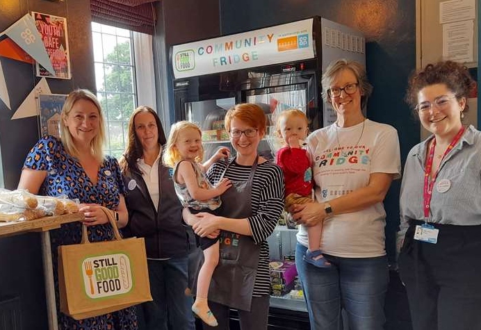 A group of people at a community fridge. 