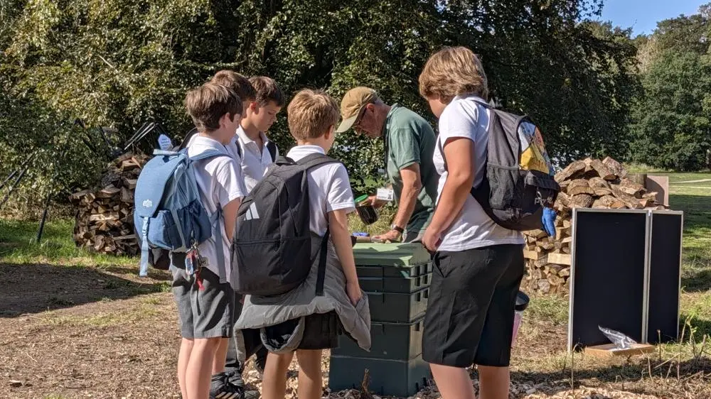 5 boys and a master composter looking at a wormery.
