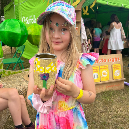 Girl in rainbow outfit with gold tin can plant pot
