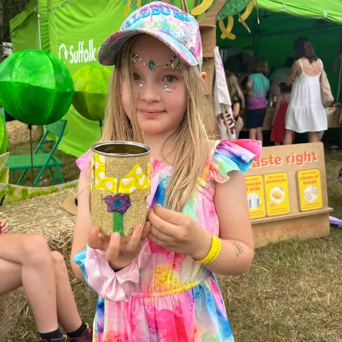 Girl in rainbow outfit with gold tin can plant pot