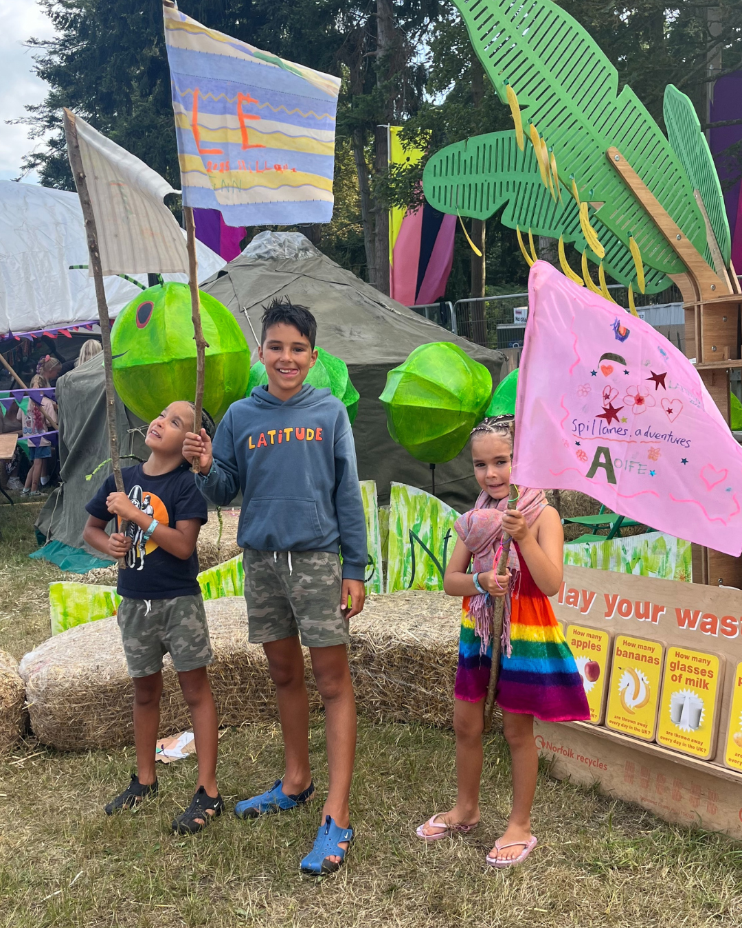 3 siblings waving flags.